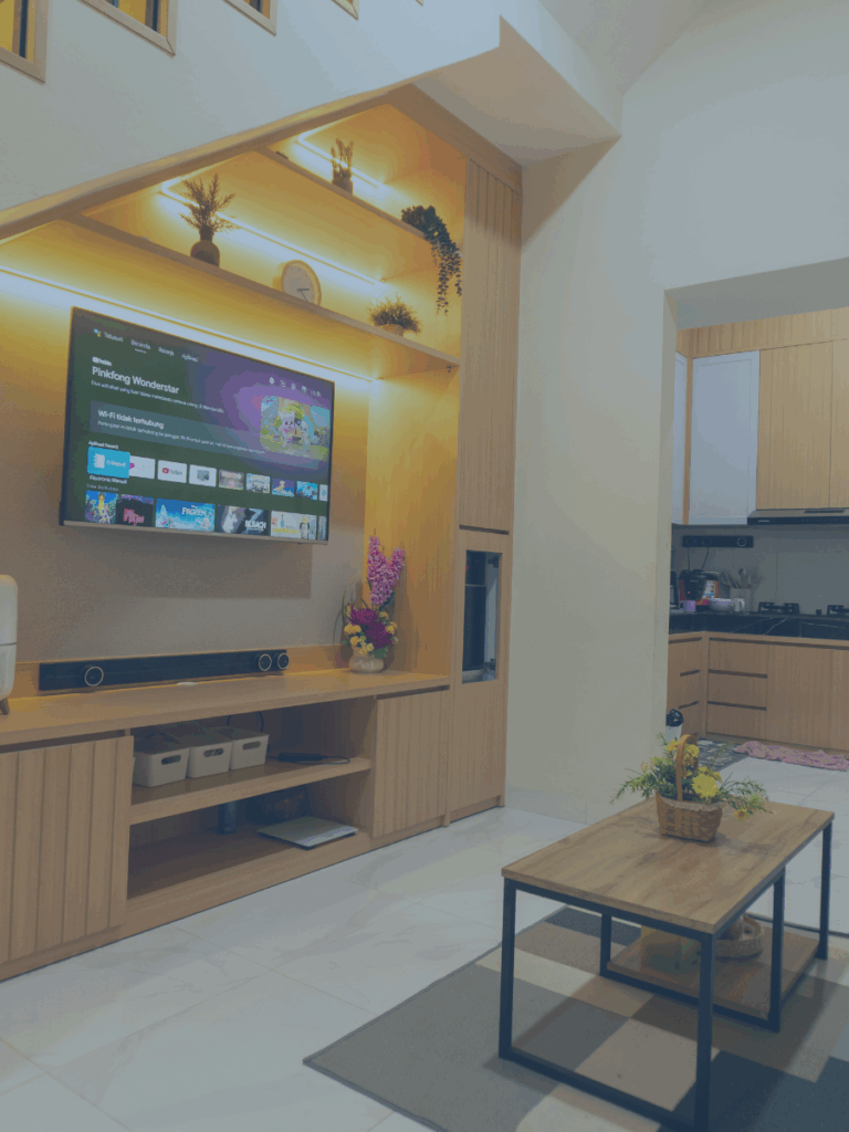 Nicely appointed living room with TV on a wooden wall.