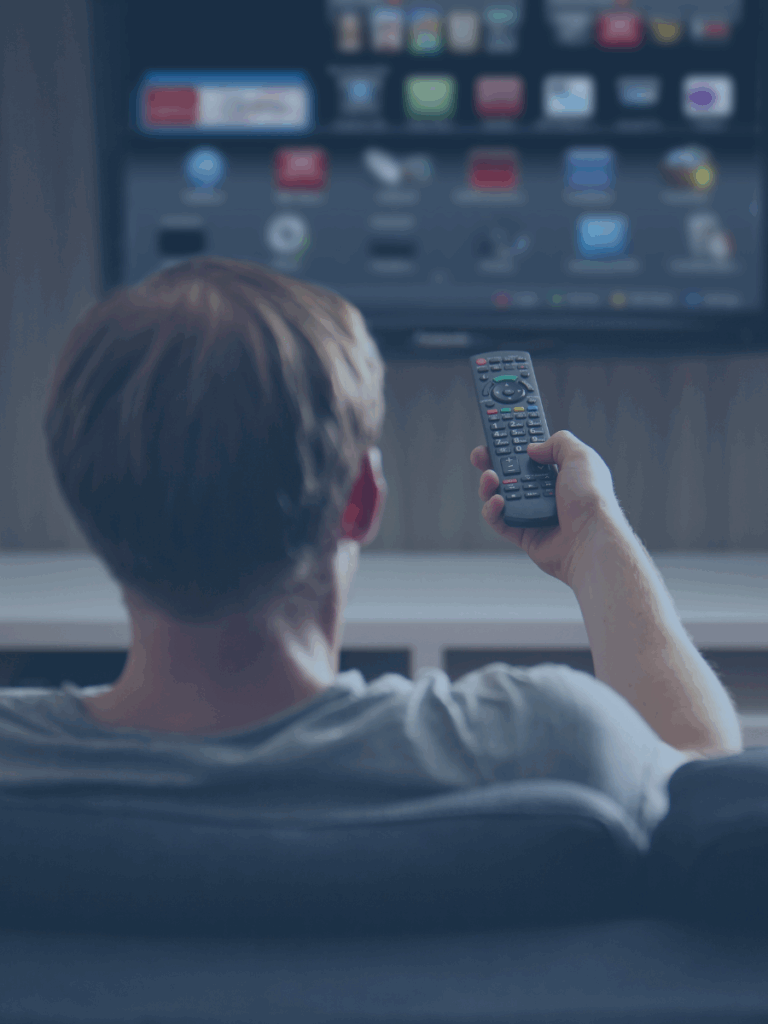 Back of a person holding a remote toward TV.