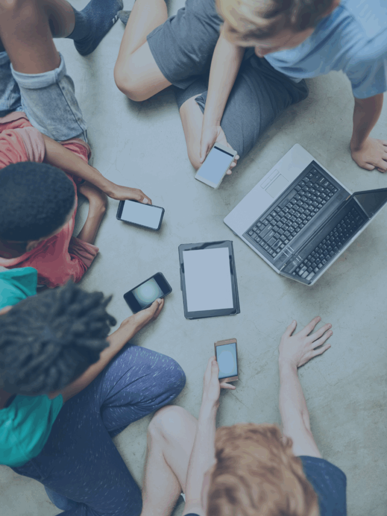 Overhead view of humans with several varying digital devices.