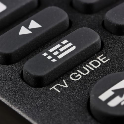 Black remote control up close with the words TV Guide under a button.